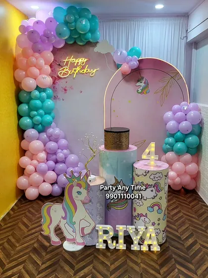 I create magical unicorn-themed parties for kids. This setup for Riya's 4th birthday features a pastel balloon garland, a custom unicorn backdrop, character cutouts, and themed plinths for the cake.