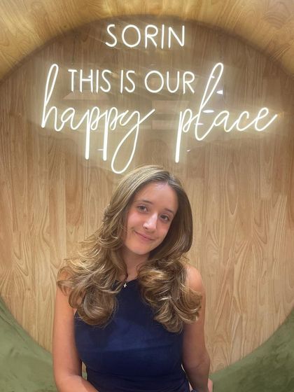 A beautiful smile from a satisfied client after her hair makeover.