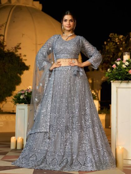 This stunning grey lehenga is perfect for a glamorous evening event. The entire outfit is covered in shimmering silver sequins and embroidery, ensuring you will sparkle all night long.
