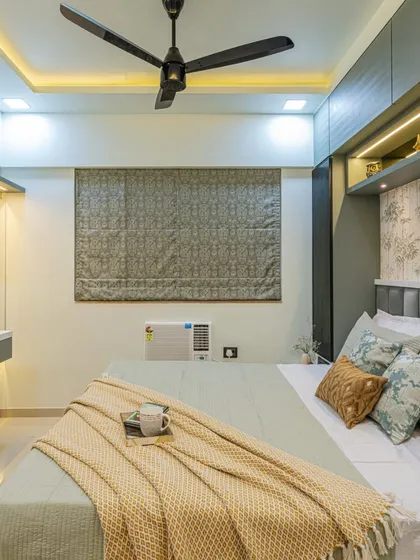 A full view of this tropical-themed bedroom. The design includes a cozy bed, a floating dressing table with a backlit mirror, and cohesive decor that makes the room feel like a peaceful getaway.