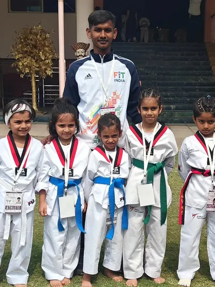 A coach stands with his team of young female competitors, who performed exceptionally well at the Pune championship.