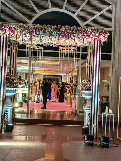 For this wedding at The Lalit, I designed a modern entrance with a sleek structure, a canopy of flowers, and dramatic crystal hangings, creating a glamorous first impression.