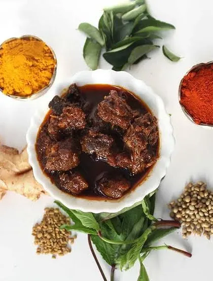 My traditional Mutton Pickle, surrounded by the fresh ginger, turmeric, and spices I use to make it. This is a bold, rich pickle made with high-quality meat.