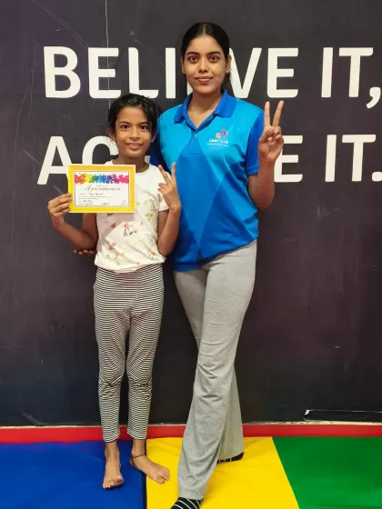 This student and her coach celebrate her new certificate with matching peace signs.