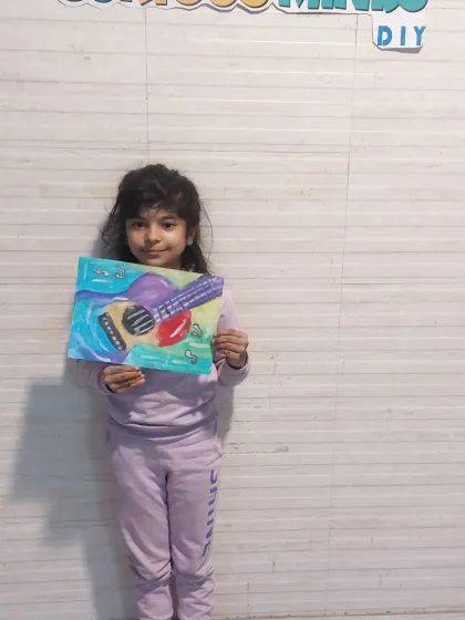 A young artist with her colorful guitar painting. We explore different subjects in our art classes to keep things fresh and exciting.