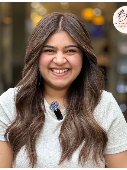 The client's joyful smile perfectly complements her new cool, classy, and chic ash blonde hair.