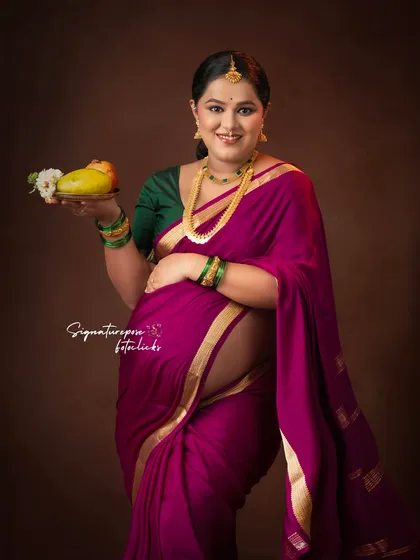 Holding a mango, a symbol of love and fertility, adds a meaningful touch to this traditional portrait.