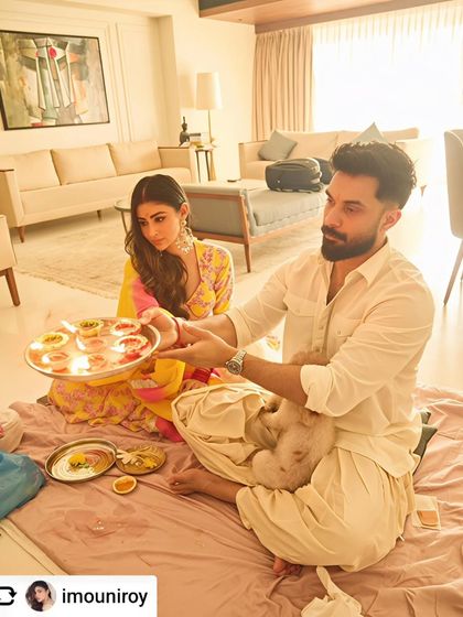 A heartfelt ritual unfolds in front of one of our paintings in Mouni Roy's home. Art is not just decoration; it becomes part of the life and memories created within a space.