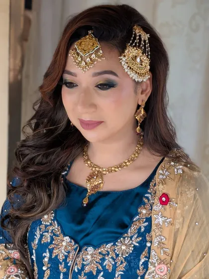 A closer look at the eye makeup, where I added a touch of green to complement her outfit, paired with voluminous side-swept curls.