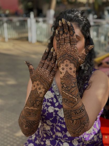 The full view of this intricate, story-driven bridal mehendi. The design extends up the arms, filled with meaningful details and traditional patterns.