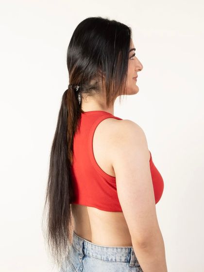 A side view of a model wearing a ponytail extension, showing the final blended look.