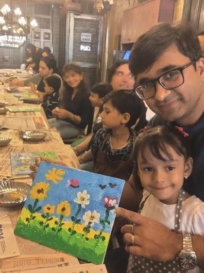 A heartwarming moment between a father and daughter as they complete their floral canvas painting at a birthday party. My sessions are designed for families to bond and share a creative experience.