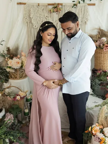 A beautiful portrait of the expecting couple. They both gently hold the baby bump, a shared gesture of love and excitement for the new life they've created together.