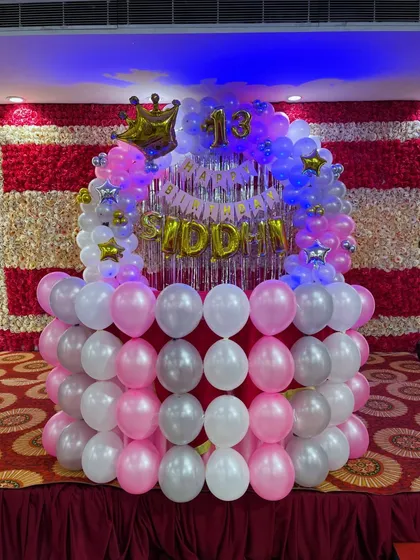 A close-up of the stage decoration for a 13th birthday, featuring a balloon base and a smaller arch on top with the name 'SIDDHI'.