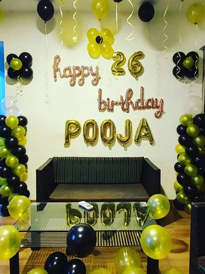 Another take on the yellow and black theme for a 26th birthday. This setup includes balloon pillars, foil letters for the name and age, and simple balloon clusters on the wall.