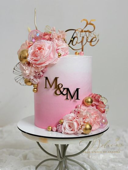 Another view of our popular pink ombre floral cake, displayed on a stand. The gradient of pink is achieved with whipped cream.