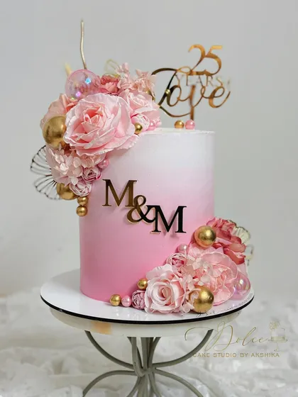 Another view of our popular pink ombre floral cake, displayed on a stand. The gradient of pink is achieved with whipped cream.