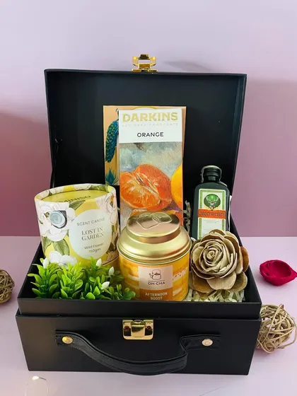 This black suitcase hamper has an orange theme, with orange-flavored chocolate, a scented candle, and a miniature Jägermeister. A unique combination for Diwali.