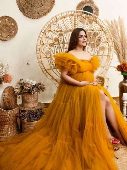 A beautiful boho-themed setup featuring a mustard yellow tulle gown and the classic peacock chair. The rustic, neutral-toned props complete this warm and earthy look.