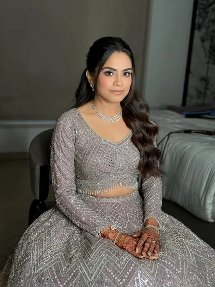 The complete look. Her hair is styled in soft waves, and her makeup is the perfect mix of glam and grace for a night of celebration.