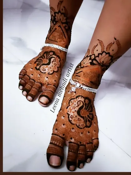 The beautiful dark stain of a peacock foot design. The silver anklets (payal) complement the traditional henna pattern perfectly.
