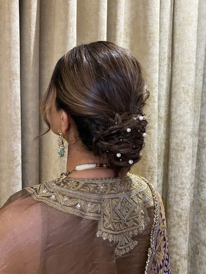 A close-up from the back, showing the intricate weaving of the bun and the scattered pearls that add a touch of shimmer.