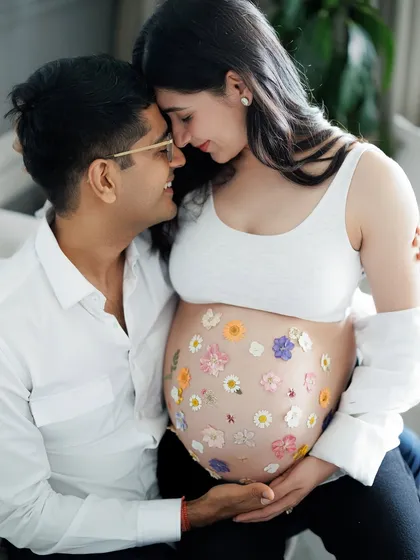 Holding their whole world between them. This intimate portrait with her belly adorned with flowers is a beautiful representation of the life and love they are growing.