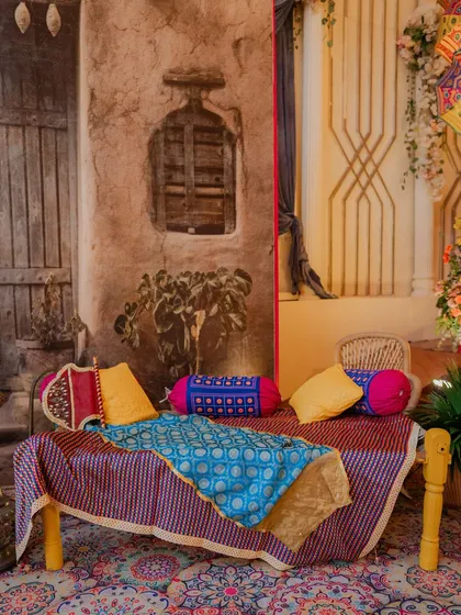 For our Punjabi Fun Night, I created this cozy seating area with a traditional charpai, adorned with colourful printed fabrics and cushions. The backdrop gives the feel of a rustic Punjabi village home.