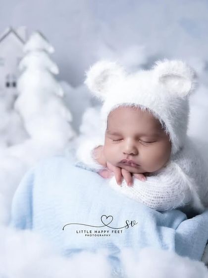 A winter wonderland for this little bear. The all-white theme with fluffy clouds and miniature houses creates a magical, snowy village scene.
