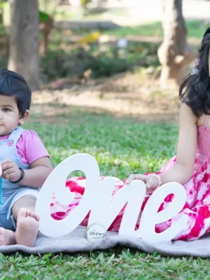 Two sisters celebrating a first birthday milestone in a sunlit garden. Capturing the special bond between siblings, big and small, is one of my greatest joys.