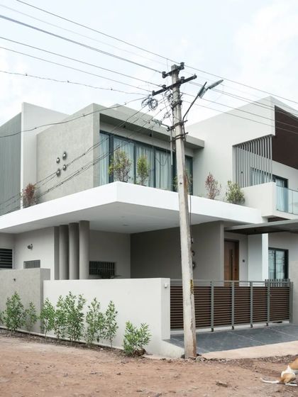 The exterior of the 'Yashodanand' residence is a composition of interlocking geometric volumes, creating a dynamic and contemporary architectural form.