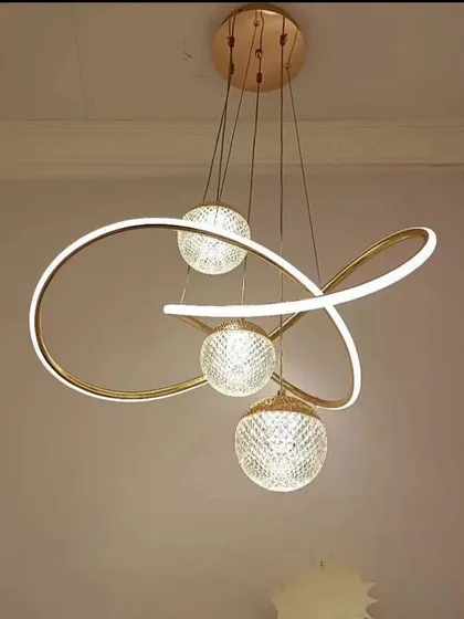 An abstract pendant light with a swirling LED ribbon and crystal-cut globes. This fixture is a piece of art, perfect for a modern home that values unique design.
