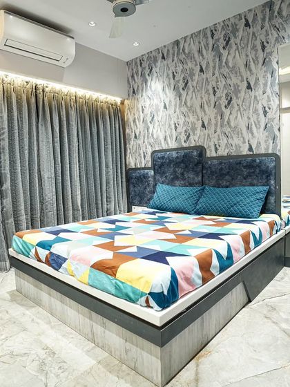 For this boy's bedroom, I used a calming blue color palette. The design includes a custom bed, a feature wall with abstract wallpaper, and mirrored panels to make the room feel more spacious.