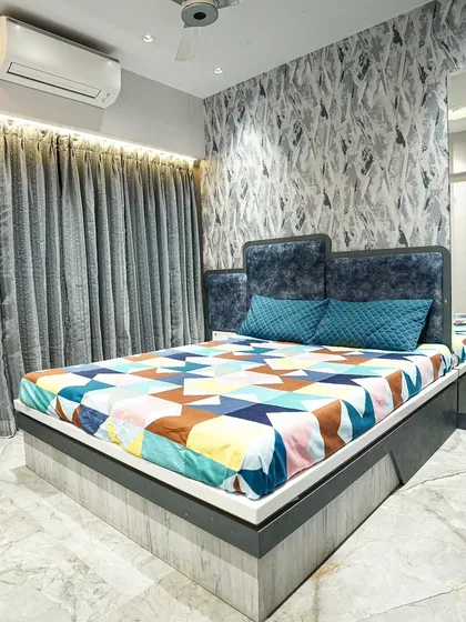 For this boy's bedroom, I used a calming blue color palette. The design includes a custom bed, a feature wall with abstract wallpaper, and mirrored panels to make the room feel more spacious.