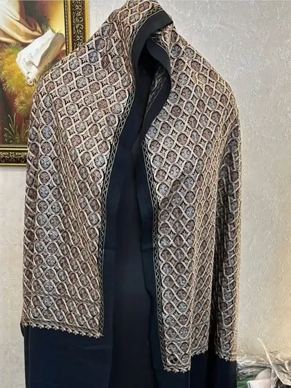 A geometric patterned Kashmir pashmina with a solid black border. The unique design makes it a modern yet classic piece.