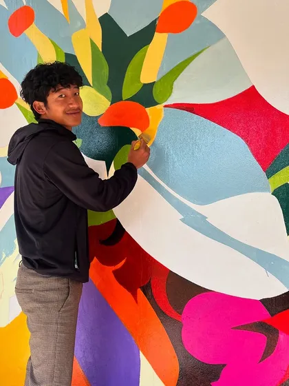 A shot of me smiling while working on the colorful abstract section of the Ziro college mural. This project was filled with good vibes and new friends.