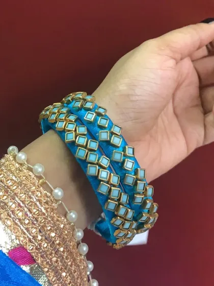 Explore my range of blue silk thread bangles, featuring different styles with kundan stones, coins, and pearl embellishments.