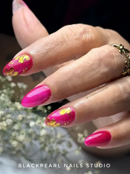 A festive and vibrant design with a hot pink cat eye polish base, adorned with delicate, hand-painted golden chrome flowers. This look is perfect for celebrations or for anyone who loves a bold, glamorous statement.