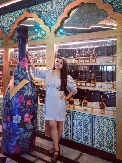 Posing with a giant decorative bottle at the party venue. The right outfit makes you feel confident and ready for any photo opportunity.