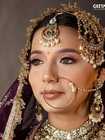 This stunning bridal look, created by one of our students, features dramatic winged eyeliner and a traditional nath. It's a testament to the detailed artistry they learn to master.