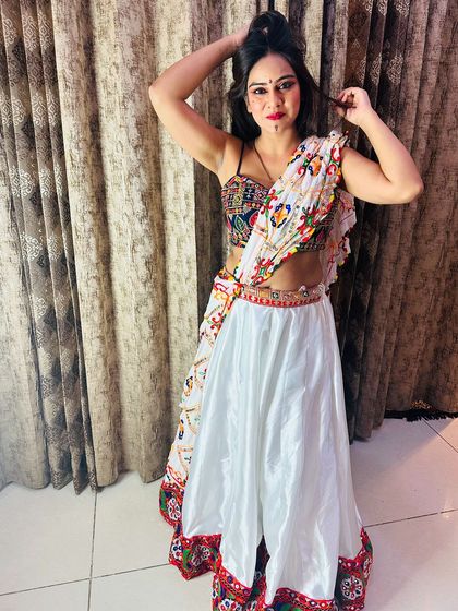A playful pose in the white satin Garba lehenga, highlighting the fun and festive nature of the outfit.
