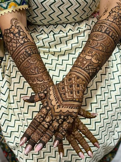 The way the henna wraps around the arms is so important. This design shows a seamless flow of patterns, creating a cohesive and elegant look.