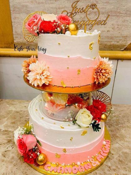 Love is sweet, and so is this cake. A beautiful two-tier engagement cake with a separator filled with flowers.