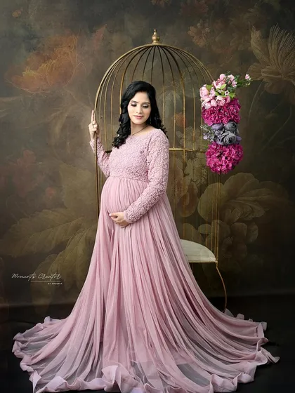A graceful portrait in a dusty pink gown. Posed next to the golden birdcage against a floral backdrop, this image is the epitome of romantic elegance.