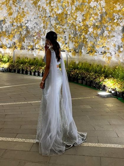 This enchanting grey fairytale lehenga is designed to make dreams come true. The shimmering sequin fabric catches the light beautifully, and the attached cape-like dupatta adds a touch of modern drama.