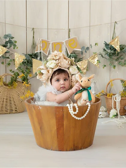 This wooden tub is one of my most versatile posing props for sitter sessions. It's paired here with a large floral bonnet and a white wood-panel backdrop to create a classic, cheerful look.