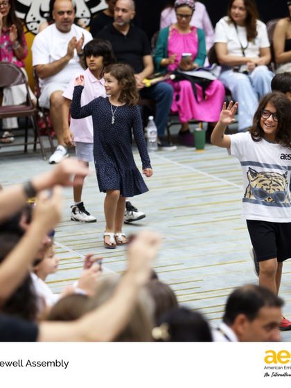 Elementary students wave to their families and friends during the Farewell Assembly. It's a heartwarming celebration of their growth, friendships, and the supportive community they are a part of.