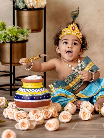 This is a duplicate of image 131. An action shot of our little Krishna, excitedly playing with his butter pot and surrounded by a bed of roses.