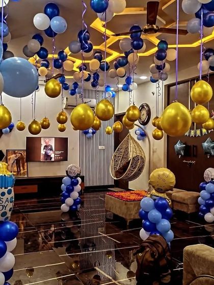 A full room decoration for a baby boy's welcome party. We filled the space with blue, white, and gold balloons on the ceiling and created balloon pillars to transform the entire room.