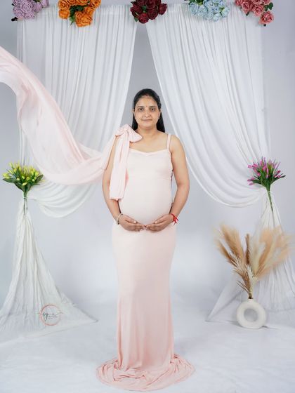 A lovely solo portrait featuring a flowing pink gown against a dreamy white curtain backdrop. The movement in the fabric adds a touch of ethereal grace.